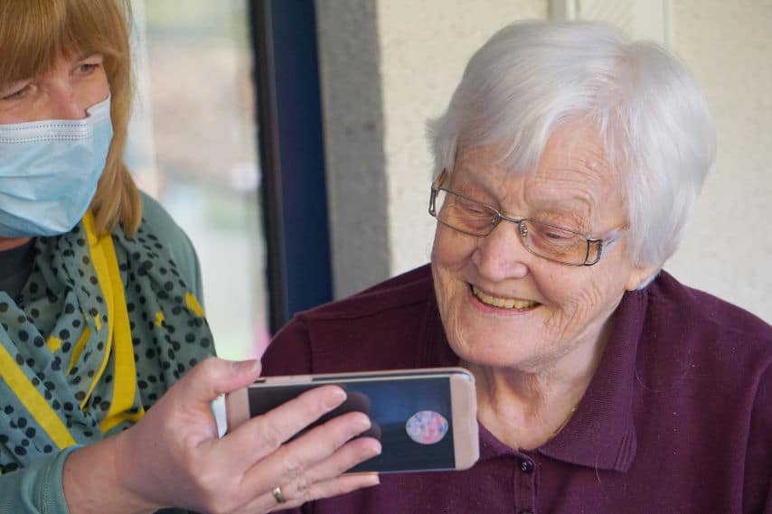 A nurse shows an older patient an educational video about her treatment on a mobile device. Picture by Georg Arthur Pflueger at Unsplash. Unsplash License. https://unsplash.com/es/fotos/TeWwYARfcM4