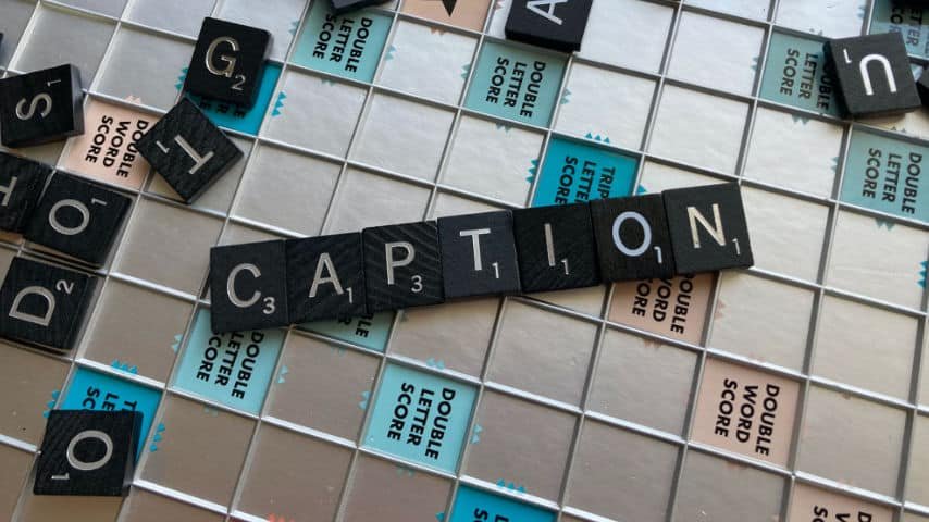 What is Closed Captioning, Difference from Subtitles. Scrabble board with "CAPTION" letter in the middle. Picture by Mónica Flores at Unplash. Unsplash License. https://unsplash.com/es/fotos/p4mFOzM-asQ