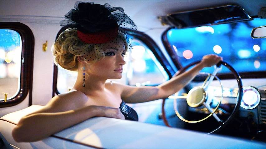 Picture of an elegant woman at the wheel of a car. For blog post The Mid-Atlantic Accent in Voice Over. Photo by Freepik: https://www.freepik.com/free-photo/beautiful-sexy-fashion-blond-girl-model-with-bright-makeup-curly-hairstyle-retro-style-sitting-old-car_6883030.htm