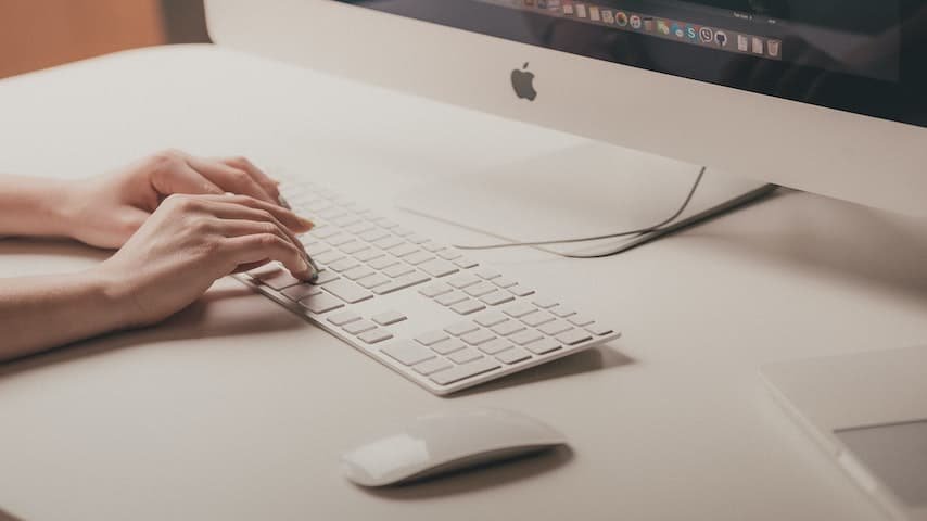 Picture illustrating a woman's hands typing on a keyboard in front of a computer. Retrieved from Unspalsh. For blog post English Subtitles and Differences In Spoken and Written Language. https://unsplash.com/photos/Hcfwew744z4?utm_source=unsplash&utm_medium=referral&utm_content=creditShareLink