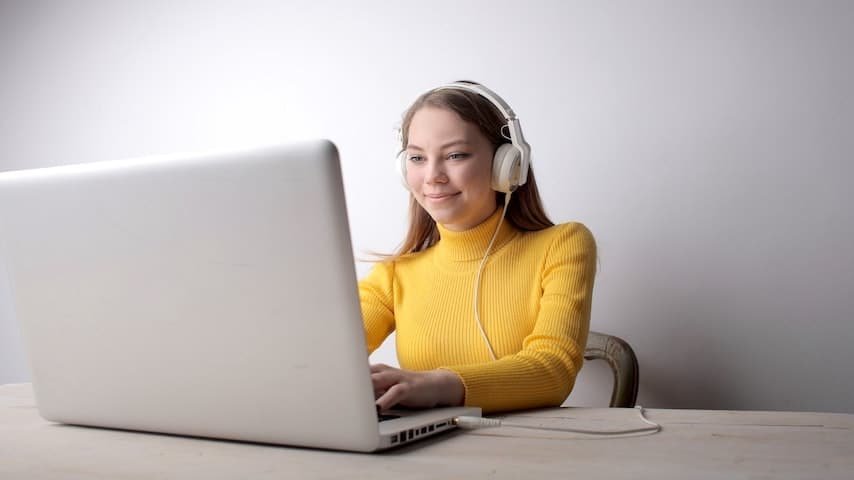 Audio Transcription and Video Transcription. Photo of a woman in yellow sweater wearing headphones using laptop. Pexels licence: https://www.pexels.com/photo/woman-in-yellow-sweater-wearing-headphones-using-laptop-3885777/
