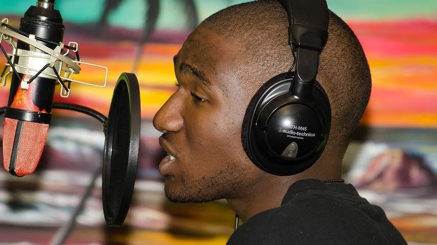 Black person recording vocals to illustrate an article on the subject of Black voice actors. Image by Landon Shaw from Pixabay
