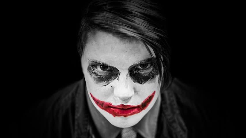 Image of a face made up to look like Batman's The Joker, to illustrate an article on the scariest voices and scariest voice overs. Photo by Hermes Rivera on Unsplash