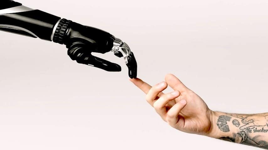 AI Translation. Image of a bionic hand and human hand finger pointing. This image is used to illustrate the article “The Rise of AI Translation”. Pexels license: https://www.pexels.com/photo/bionic-hand-and-human-hand-finger-pointing-6153354/