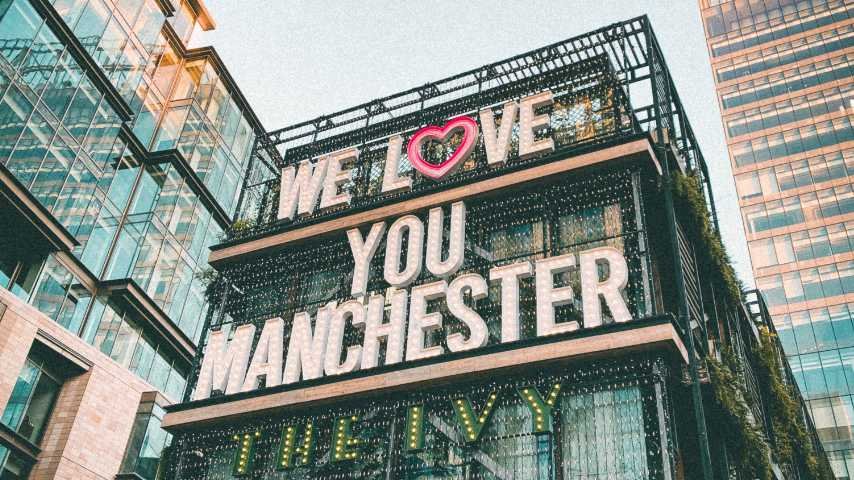 Manchester Accent 101: Unlocking Mancunian English. Photo of a Neon Sign with the text “We love you Manchester” at the top of a modern building at Manchester, UK, by Surya Prasad at Unsplash. Unsplash License. https://unsplash.com/es/fotos/Awnib4OXGsI