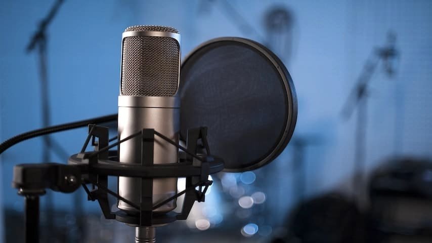 Microphone Shock Mount. Image of a close-up of a professional microphone with a pop-filter and shock mount. This image is used to illustrate the article “Mastering Microphone Shock Mounts”. Freepik license: https://www.freepik.com/free-photo/close-up-professional-microphone-pop-filter_20933664.htm